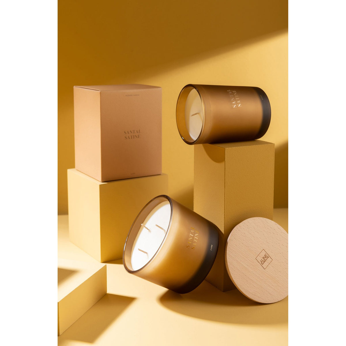 Geurkaars Accords Essentiels Santal Satiné 38 Uur van J-Line op decoratieve blokken in een warme sfeerfoto