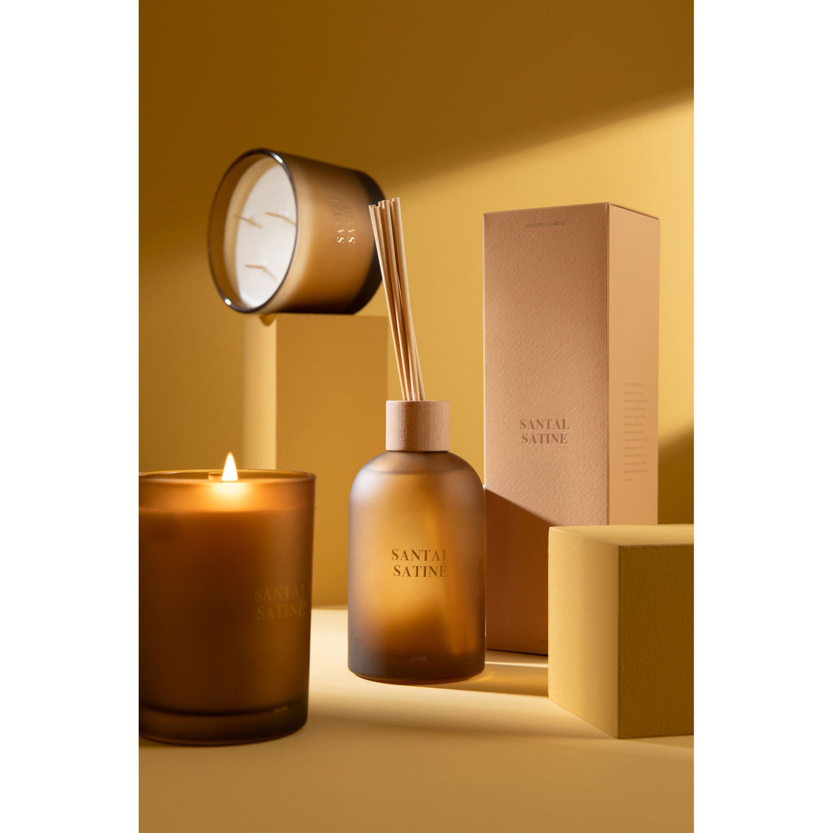 Geurstokjes Accords Essentiels Santal Satiné 250ml van J-Line samen met bijpassende geurkaars uit de Santal Satiné lijn