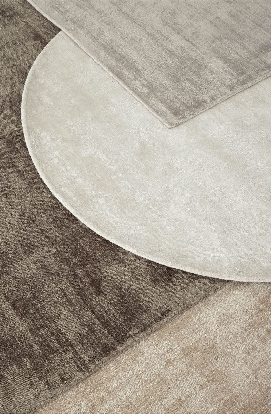 Ronde en rechthoekige La Belle vloerkleden van MUST Living in beige en saliegroen naast elkaar