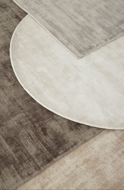 Ronde en rechthoekige La Belle vloerkleden van MUST Living in beige en saliegroen naast elkaar