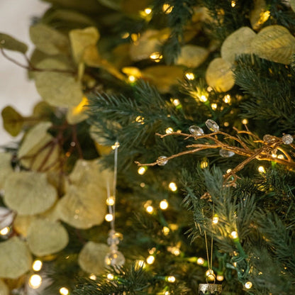 Kerstbal Geruit Glas Small van J-Line hangend in een kerstboom met warme lichtjes