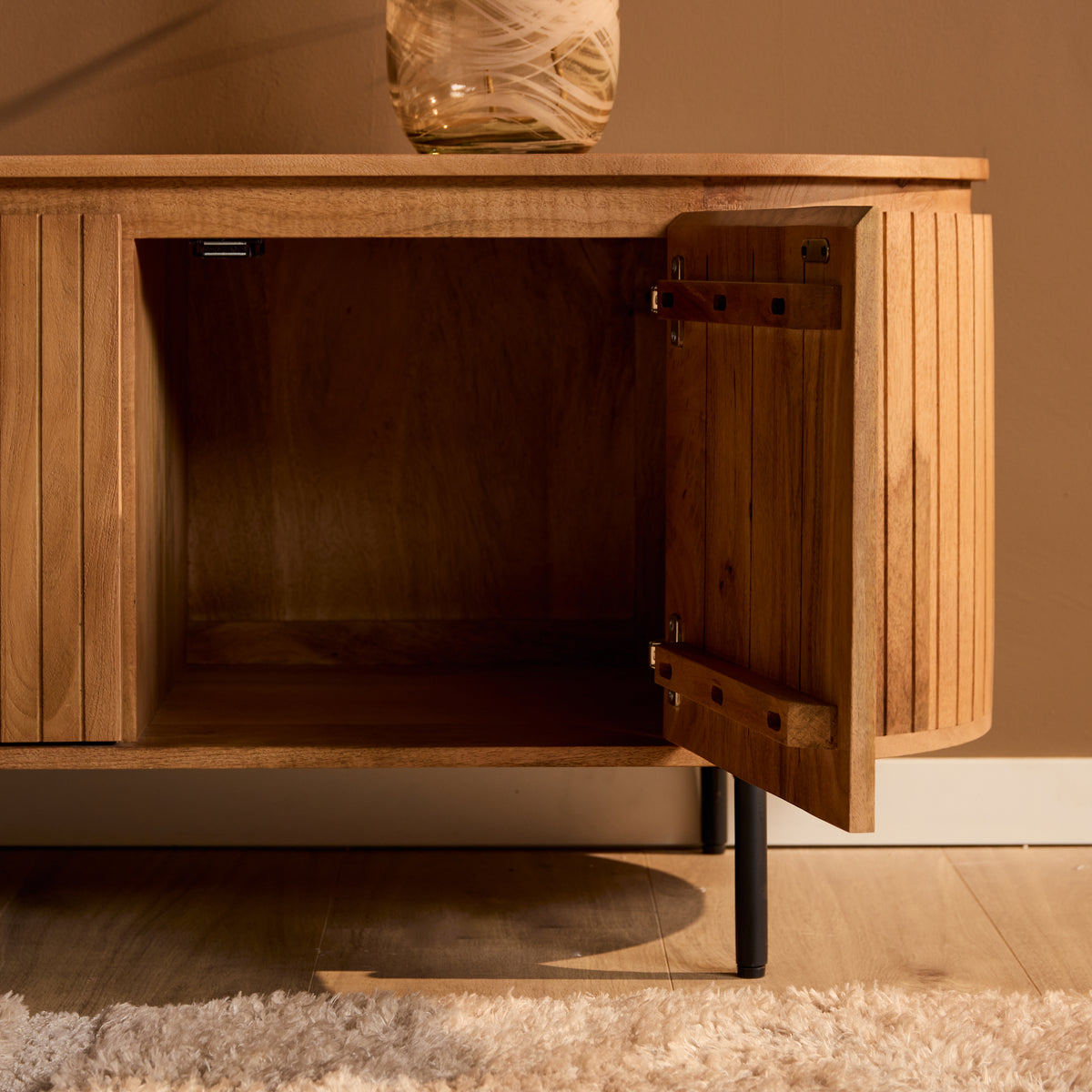 Geopend tv meubel Solana naturel met legplank in een woonkamer